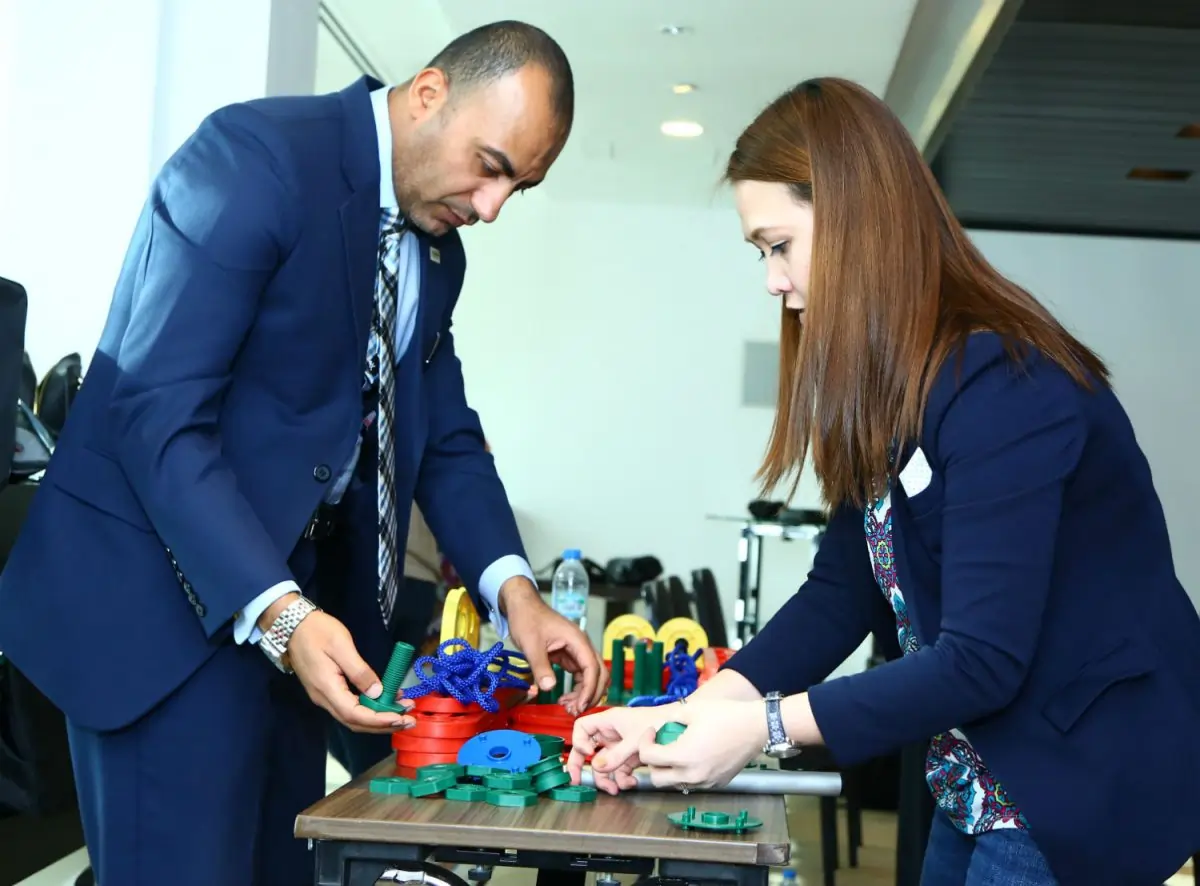 Participants engaging in the Taller Stack activity, demonstrating leadership and change management skills.