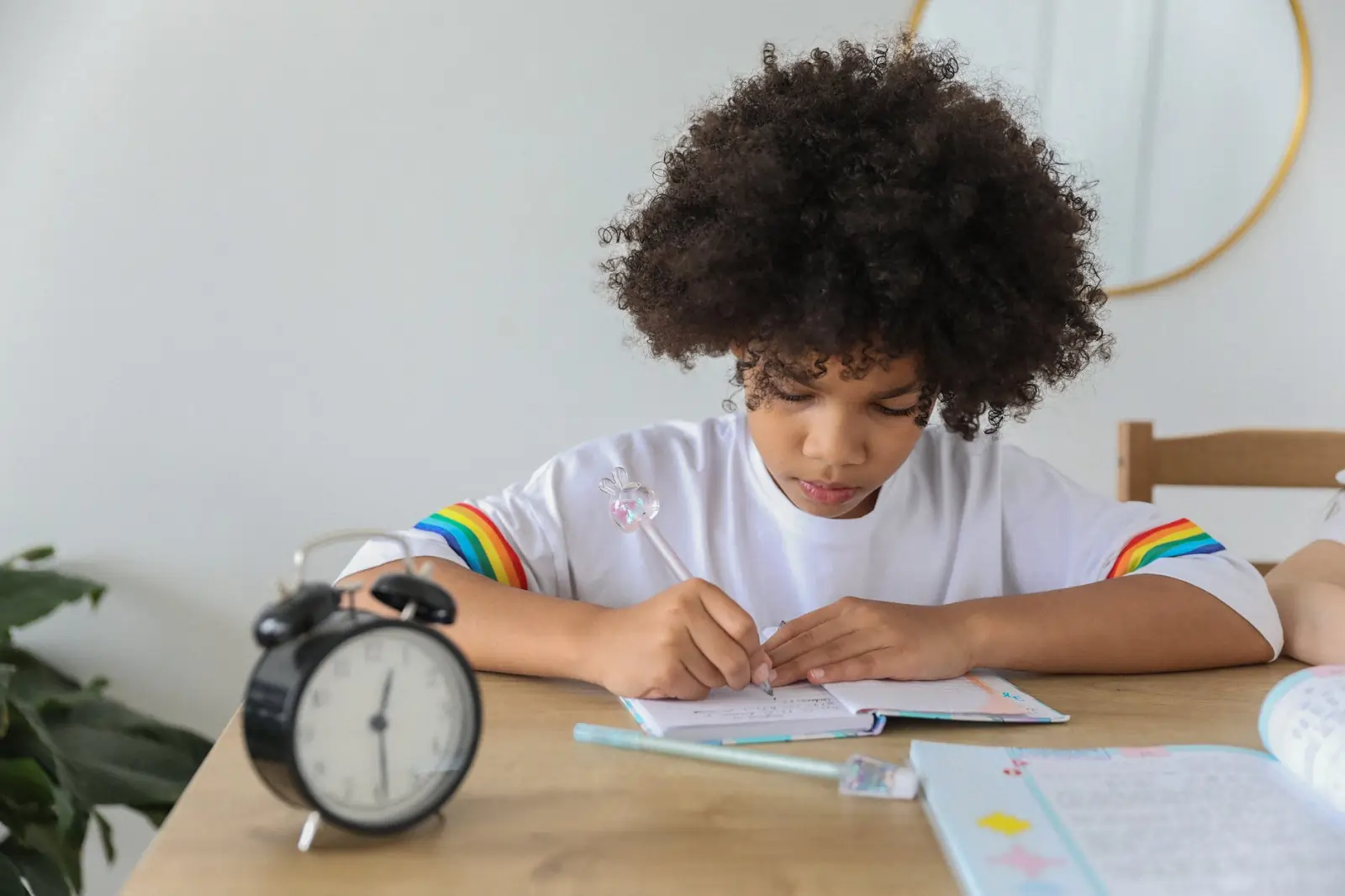 A child recording data at a table while conducting a STEM activity to measure reaction times, actively designing and building their own measuring device.