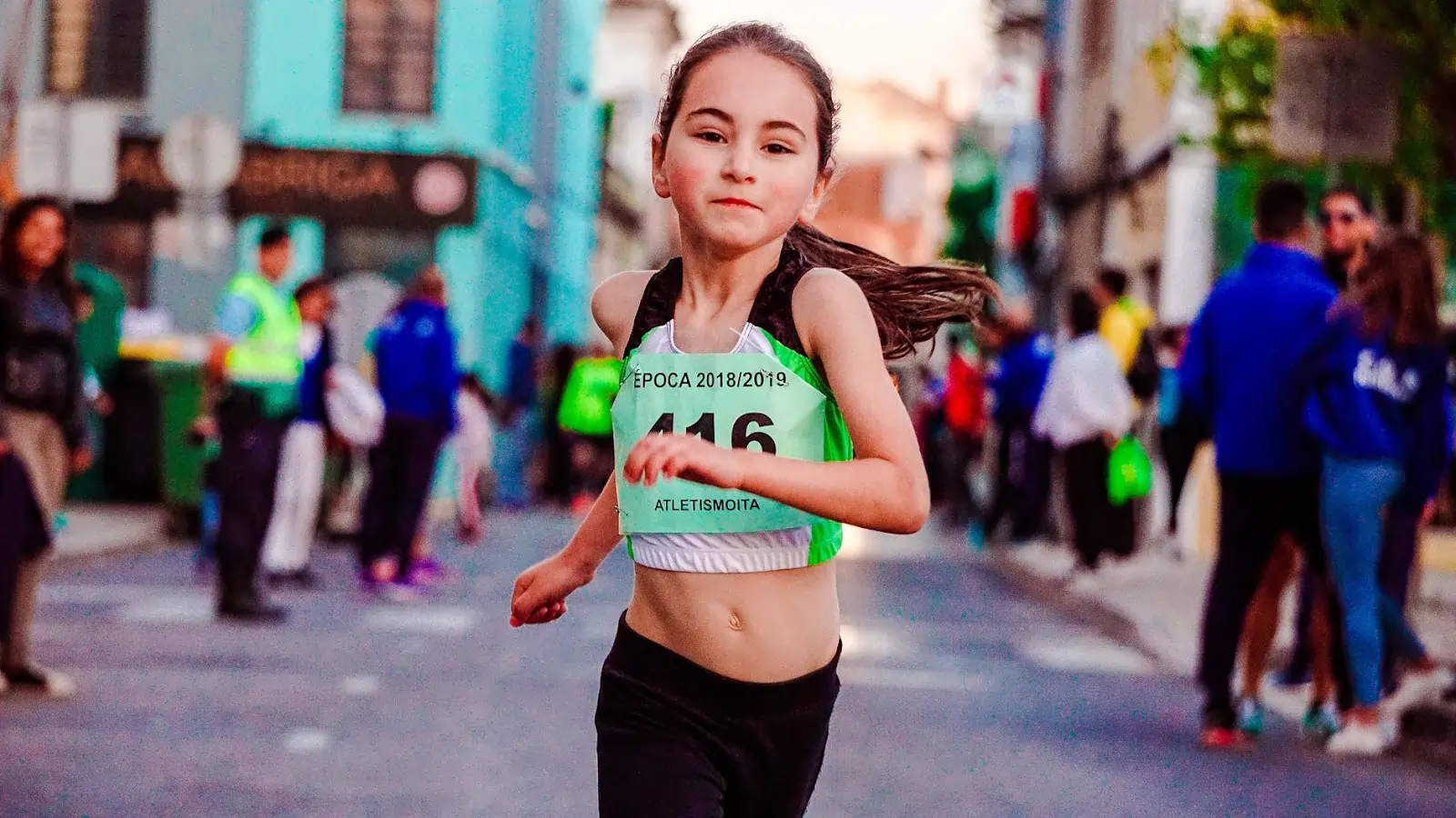 A child running on a track, actively exploring the concept of distance on different lanes and considering how to make a race fair in a STEM activity focused on running tracks.