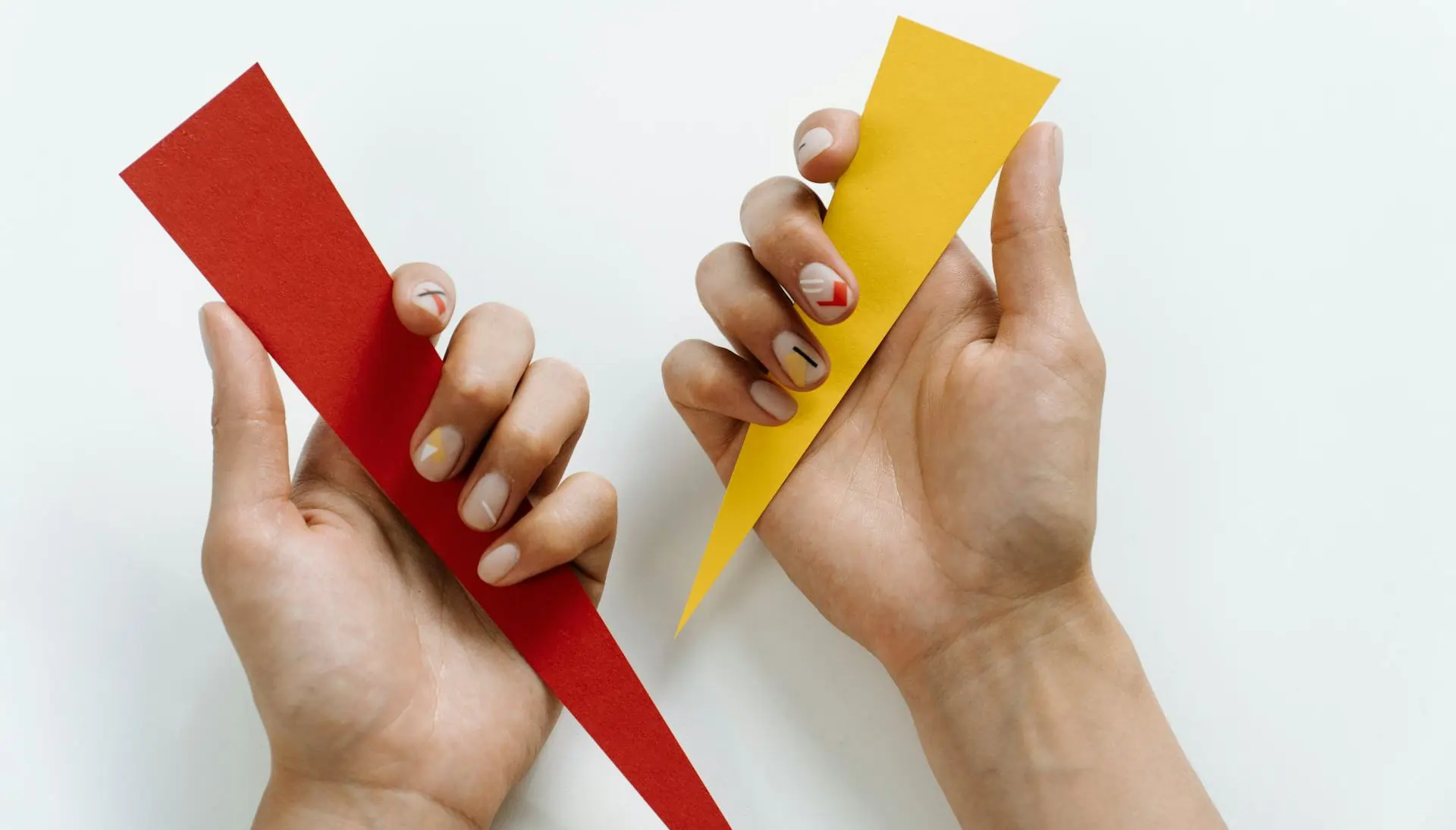 Two hands holding triangle shapes from the Broken Square activity, fostering problem-solving and collaboration.