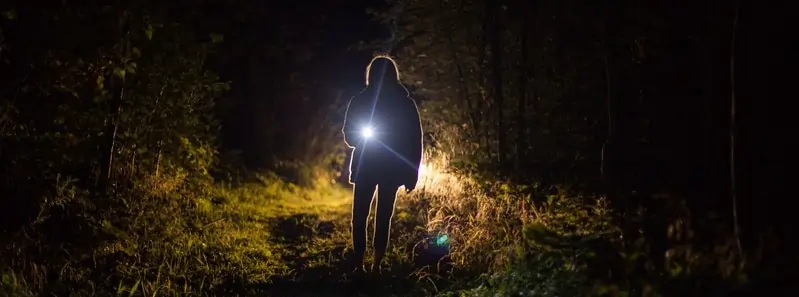 A child using a torch light to communicate in Morse Code during a STEM activity focused on signaling.