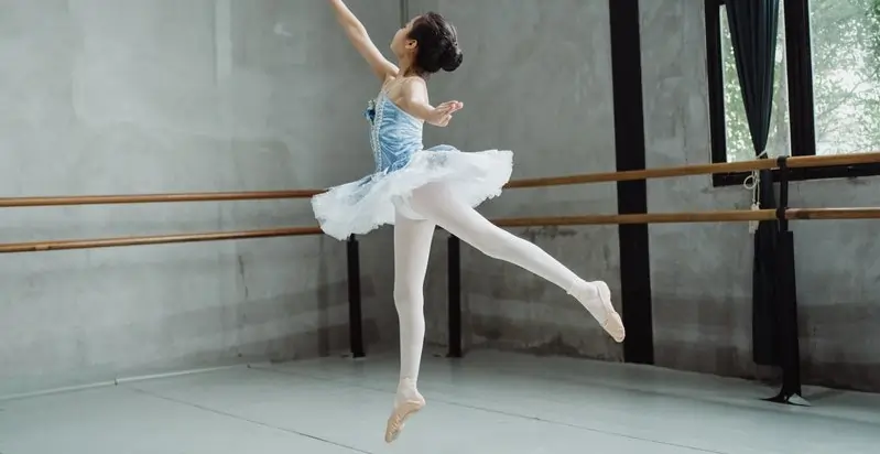 A child dancing a tiny ballerina powered by magnets, actively engaging in a STEM activity exploring magnetism, circuits, and wire work.