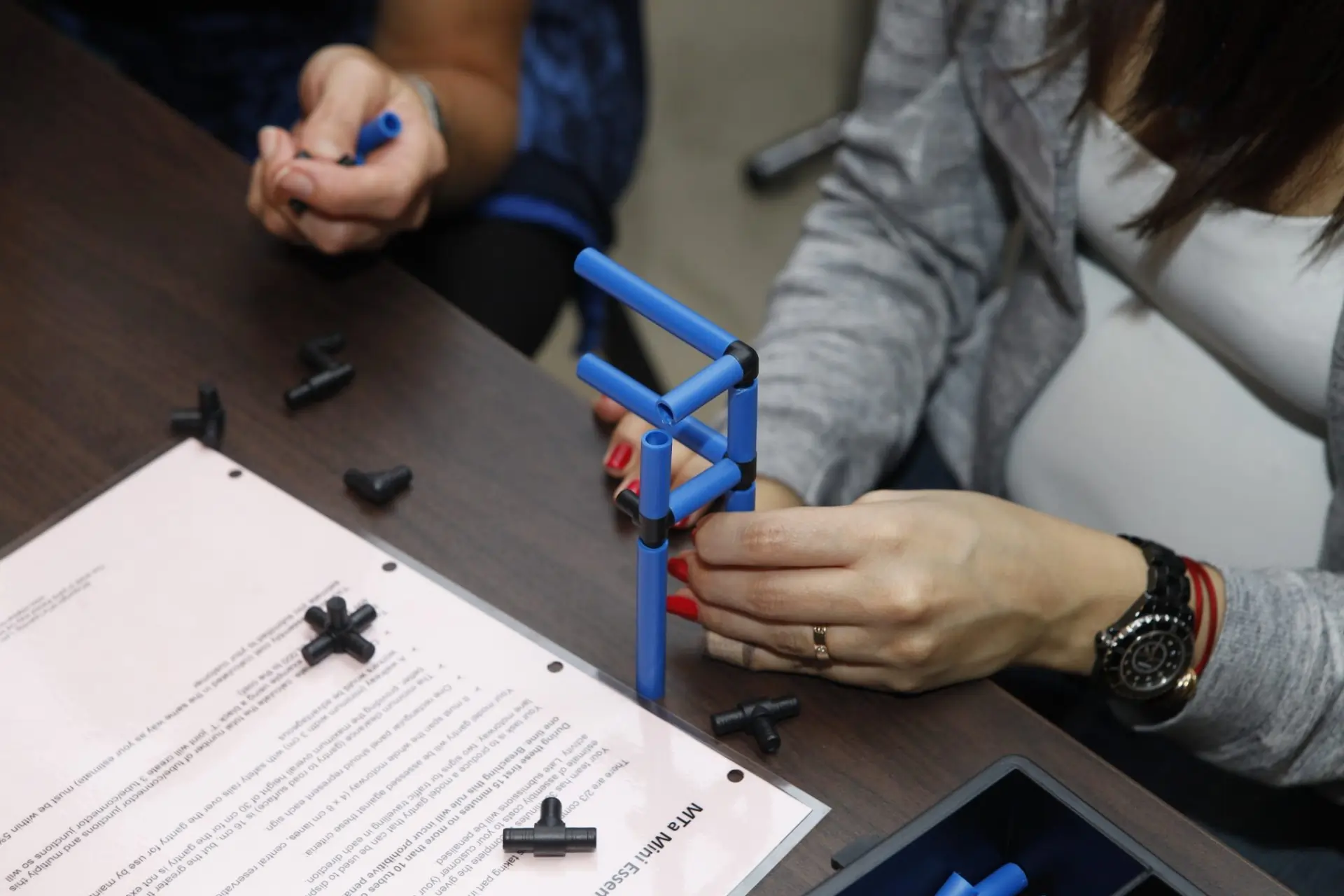 Participants using the MTa Mini Kit for the 'Promises, Promises' activity, exploring leadership and communication.